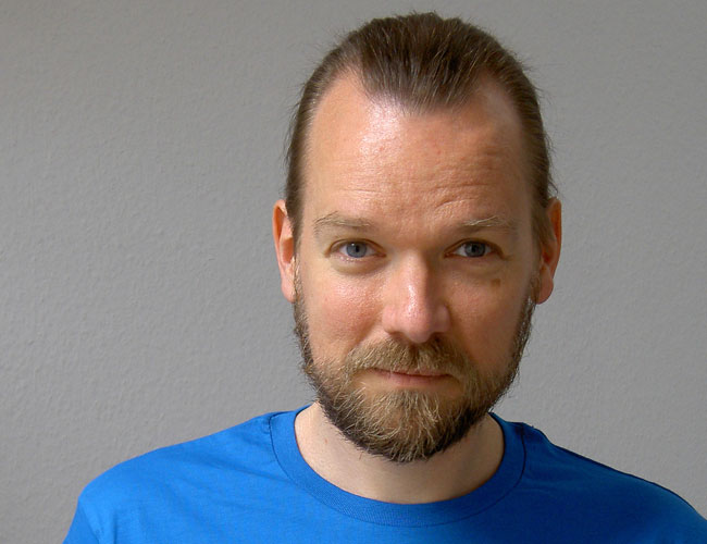 Urs looking into the camera, hair invisibly tied behind his head